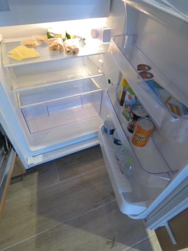 otwarta lodówka z otwartymi drzwiami i jedzeniem w środku w obiekcie Villa Einstein Apartments w Antwerpii