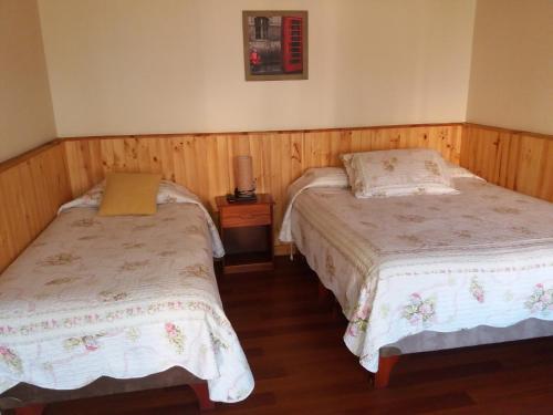 a bedroom with two beds and a lamp on a table at Hostal Balmaceda La Serena in La Serena