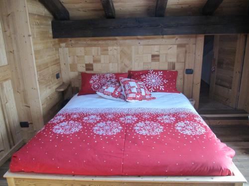 a bed with red and white pillows on it at Maison Des Abeilles Vda Gressan n 0028 in Gressan
