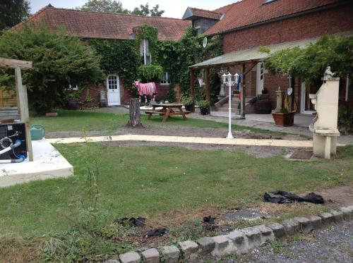 a backyard of a house with a picnic table and a horse statue at Chambre d'Hotes La Chaiserie in Romeries