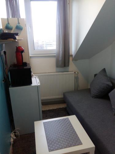 a small living room with a couch and a window at Private Studio Brussels Airport in Brussels