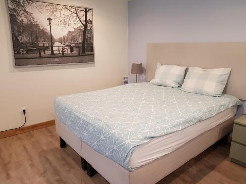 un letto in una camera da letto con una foto sul muro di Logie Rotem a Dilsen-Stokkem