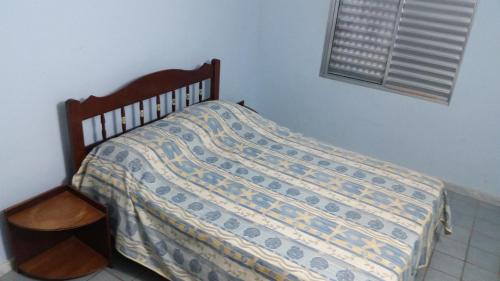 a bed with a quilt on it in a bedroom at Flat Condominio Gaivotas Alcobaça BA a 100 metros do mar in Alcobaça