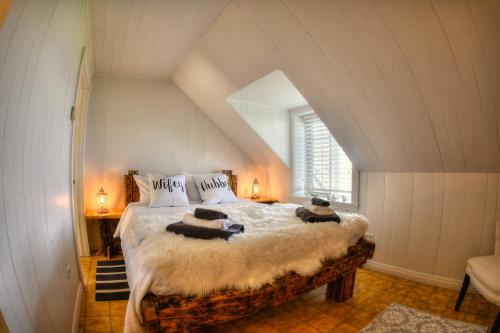 um quarto com uma cama grande num sótão em Les 2 Iles - Les Chalets Spa Canada em La Malbaie