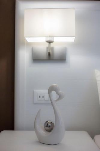 a white swan statue sitting on a table under a light at Suites Sorrento Elegance in Sorrento