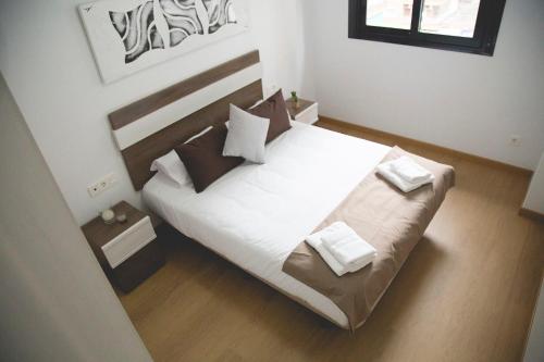 - une chambre dotée d'un grand lit avec des draps et des oreillers blancs dans l'établissement Be Free Granada, à Grenade