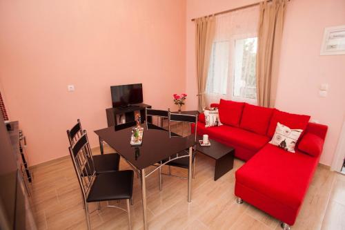 ein Wohnzimmer mit einem roten Sofa und einem Tisch in der Unterkunft Kentrikon Suites in Polychrono