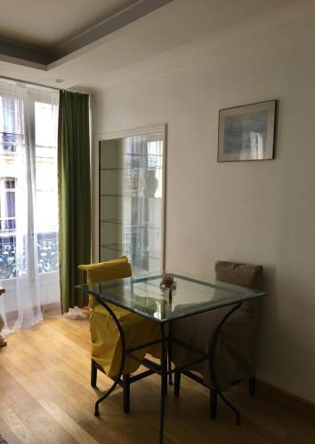 une salle à manger avec une table et des chaises en verre dans l'établissement Eco Champs Elysees, à Paris