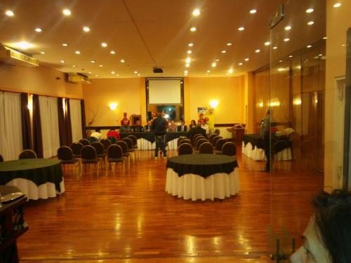 a room with tables and chairs and a grand piano at Quintana Hotel in San Luis