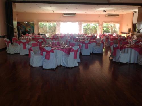 a room full of tables and chairs with red bows at Quintana Hotel in San Luis