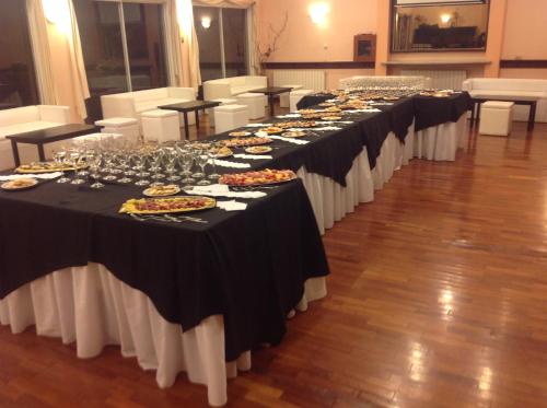 a row of tables with plates of food on them at Quintana Hotel in San Luis