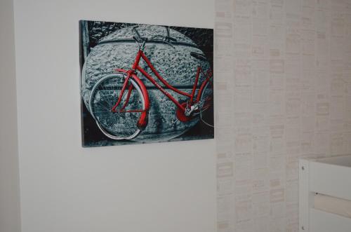 a painting of a red bike hanging on a wall at Penzion U Žabáka in Mikulov