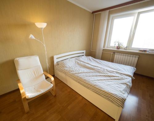 モスクワにあるU-Apart SKYのベッドルーム1室(ベッド1台、椅子、ランプ付)
