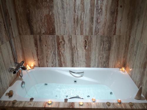 bagno con vasca bianca e candele di Apartamento Las 4 Palmeras a Cordoba