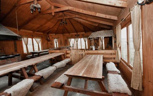 a room with wooden tables and benches in a cabin at Estancia Dos Elianas in Torres del Paine