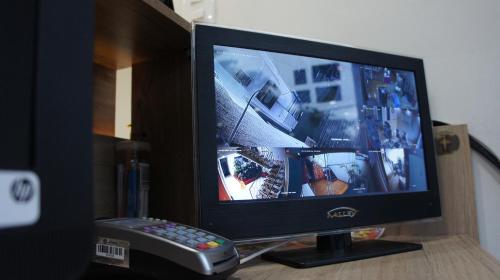 a computer monitor on a desk with a remote control at Hotel Parque del Perro in Cali