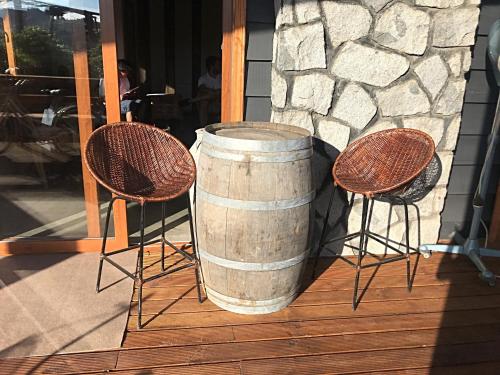 a barrel and two chairs on a porch at Hotel 381 Panguipulli in Panguipulli