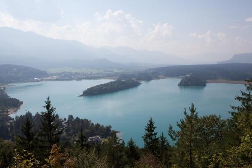 a view of a lake with trees and mountains at Ferienhäuser Glück Auf, Sauna, Hottubs in Arnoldstein
