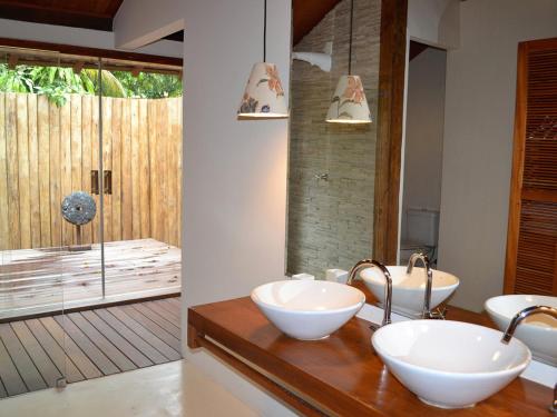 a bathroom with two sinks and a large mirror at Camauí Hotel in Barra Grande