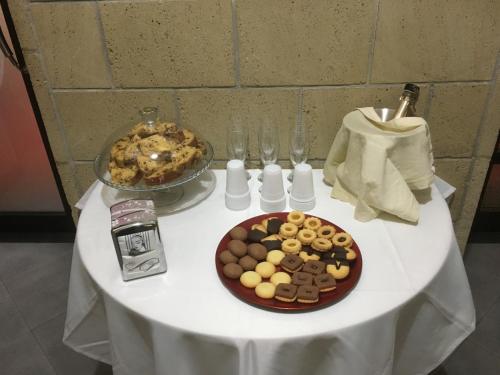 a table with a plate of cookies and a pie at Hotel Nettuno in Naples