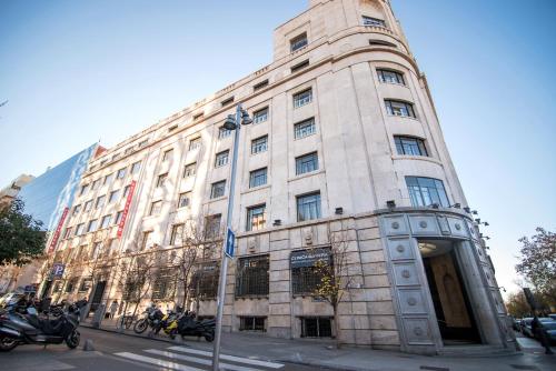 un edificio blanco alto en la esquina de una calle en Petit Palace President Castellana en Madrid