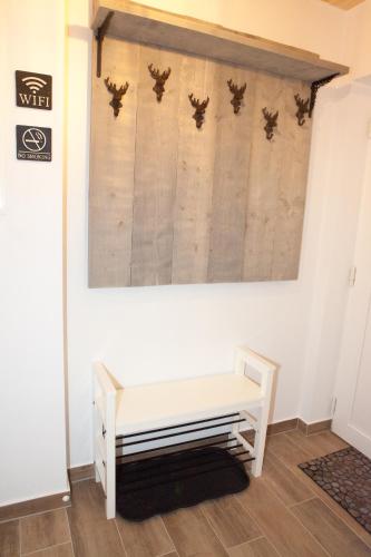 a white bench in a room with a wall at Ferienhäuser Glück Auf, Sauna, Hottubs in Arnoldstein