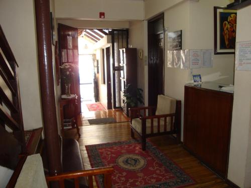 a living room with a hallway with a room with a table at Hostal Santa María Gracia in Quito