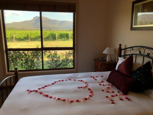 Una cama con un corazón hecho de rosas rojas en Nightingale Villas, en Broke