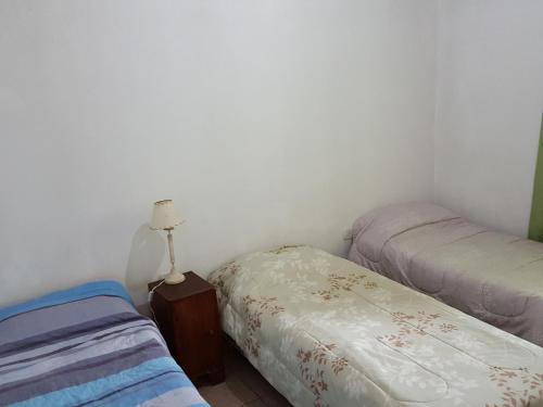 a bedroom with two twin beds and a lamp at Cabañas Años Verdes in Sarmiento