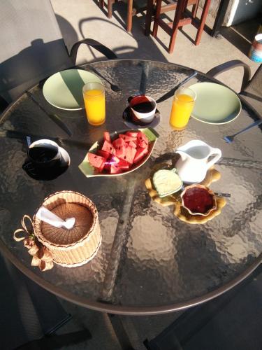 een tafel met een fruitschaal en een glas sinaasappelsap bij Mini-golf **** & Resort Ubon Ratchathani in Ubon Ratchathani