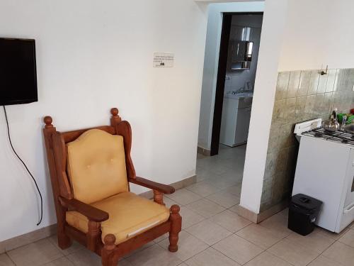 a chair sitting in a room with a kitchen at Cabañas Años Verdes in Sarmiento