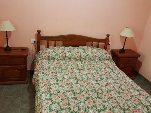 a bedroom with a bed with a floral bedspread at Cabañas Años Verdes in Sarmiento