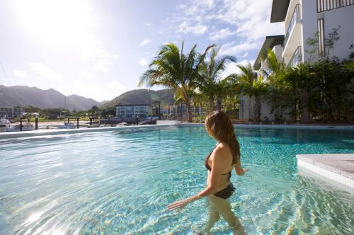 a woman is standing in the water in a swimming pool at Peppers Blue on Blue in Nelly Bay