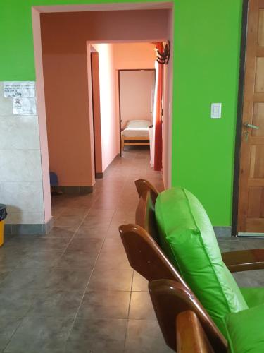 a room with green walls and brown chairs and a hallway at Cabañas Años Verdes in Sarmiento