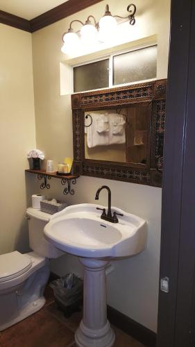 bagno con lavandino, servizi igienici e specchio di Tuscan Springs Hotel & Spa a Desert Hot Springs
