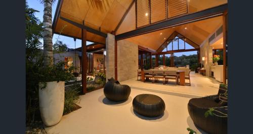 a house with two large wooden stools in front of it at Niramaya Villas and Spa in Port Douglas