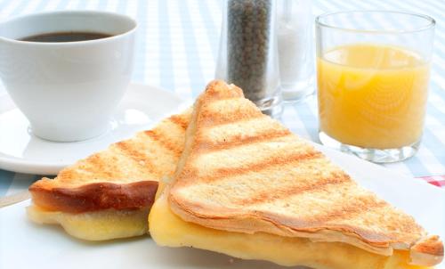 een bord met twee tosti's en een kop jus d'orange bij Casa de la Patagonia in Puerto Natales