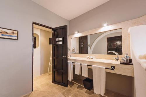 a bathroom with a sink, toilet, and mirror at Hotel Hacienda Mérida in Mérida