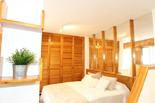 マラガにあるViviendaVelardeの木製の壁のベッドルーム1室、ベッド1台(白いシーツ付)