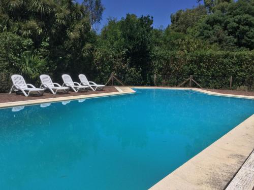 a swimming pool with two lawn chairs and a pair at Los 12 Robles in Batán