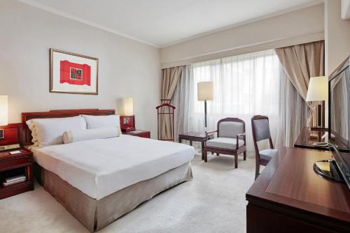 a hotel room with a bed and a television at The Howard Plaza Hotel Taipei in Taipei