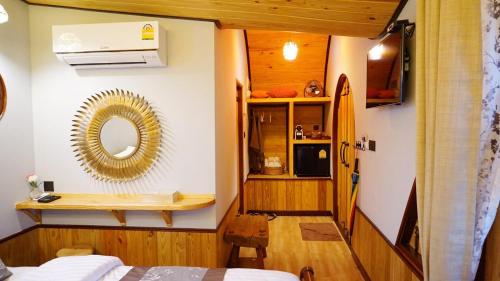 a bedroom with a mirror and a surfboard on the wall at Kiri Pura Resort in Khao Kho