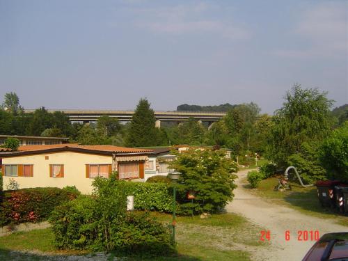 a train is passing by a house with a road at Campeggio Piano Grande in Baveno