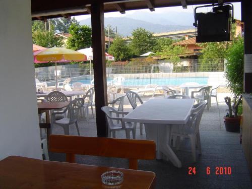 a patio with tables and chairs and a pool at Campeggio Piano Grande in Baveno