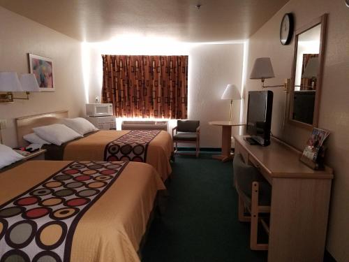 a hotel room with two beds and a television at Simple Rewards Inn in Guymon
