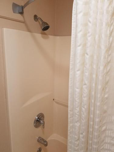 a bathroom with a shower with a shower curtain at Simple Rewards Inn in Guymon