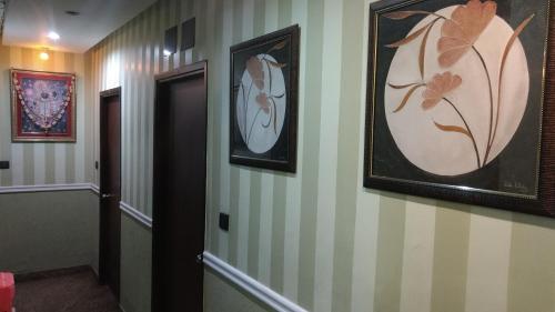 a hallway with two pictures on the wall and a door at Bhammar's Inn - A Pure Veg in Kolkata