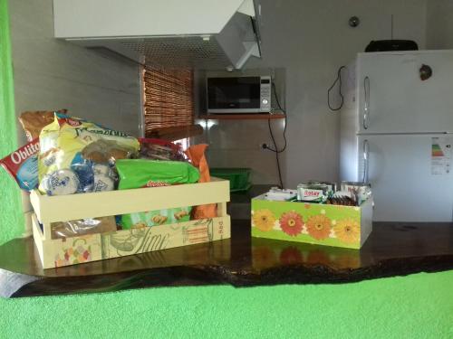 a table with boxes of food and a refrigerator at Cabañas Espinillos del Lago in Potrero de Garay