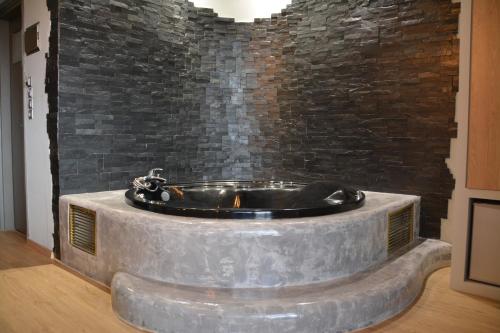 a large stone tub in a room with a brick wall at Scorpios Sea Side Hotel in Piraeus
