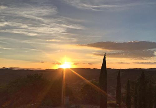 a sunset with the sun setting over the mountains at Villa Cavagnetti in Pietralunga